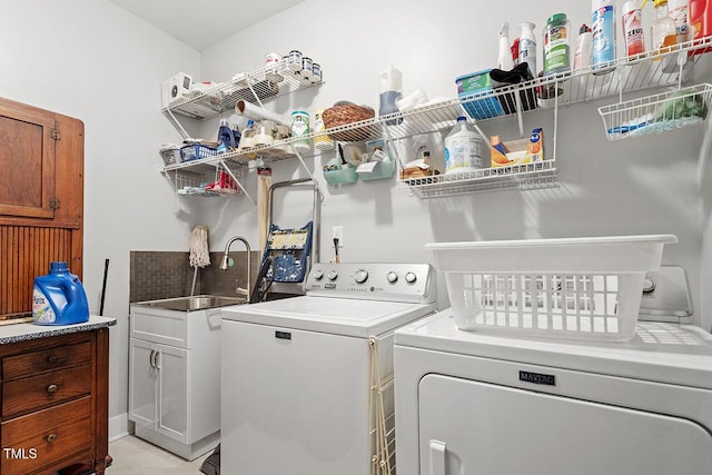 clothes washing area with washer and dryer and sink