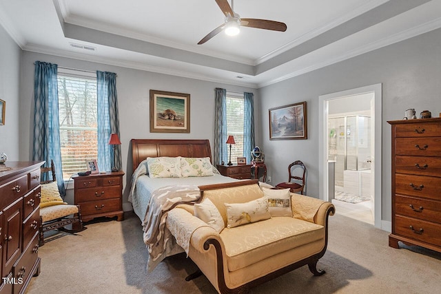 carpeted bedroom featuring ceiling fan, a raised ceiling, ornamental molding, and connected bathroom