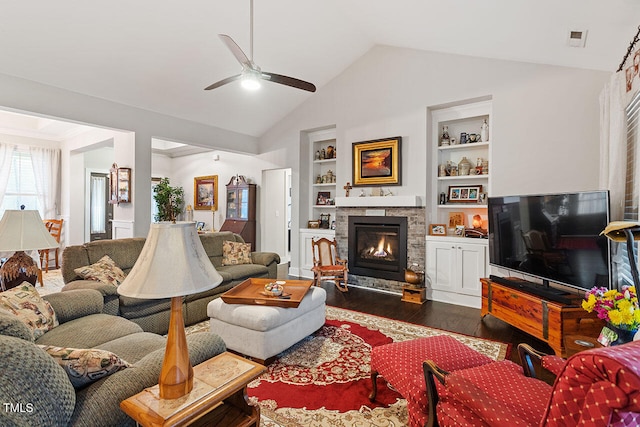 living room featuring ceiling fan, a stone fireplace, built in features, dark hardwood / wood-style floors, and vaulted ceiling