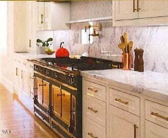 kitchen featuring light stone counters, high end stainless steel range, and wood-type flooring