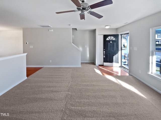 carpeted foyer with ceiling fan