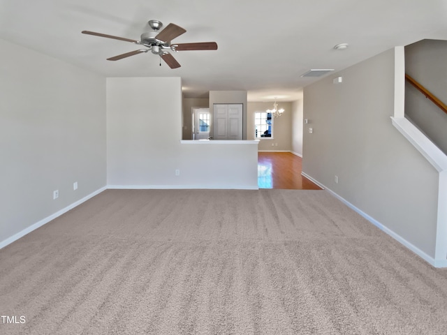 unfurnished living room with carpet and ceiling fan with notable chandelier