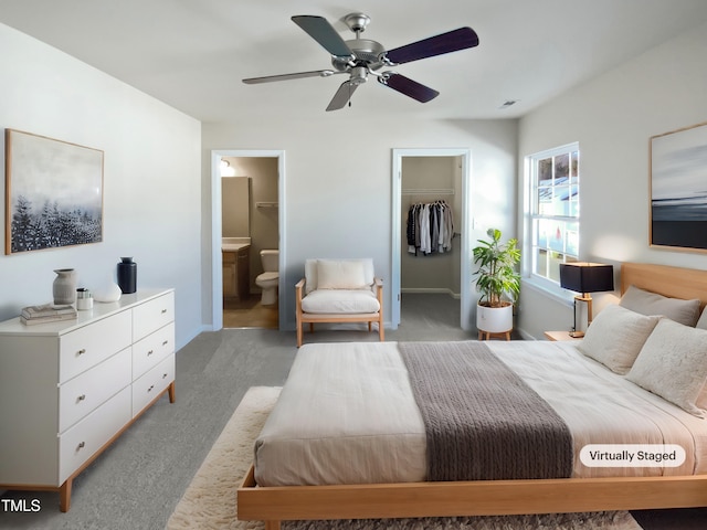 carpeted bedroom featuring ceiling fan, a walk in closet, connected bathroom, and a closet