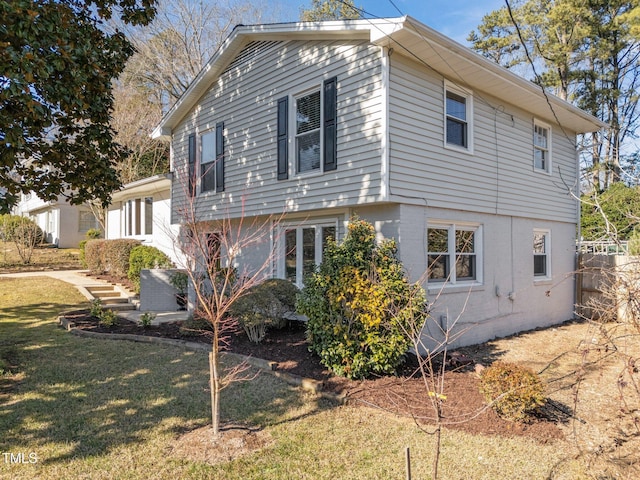 view of side of home with a yard