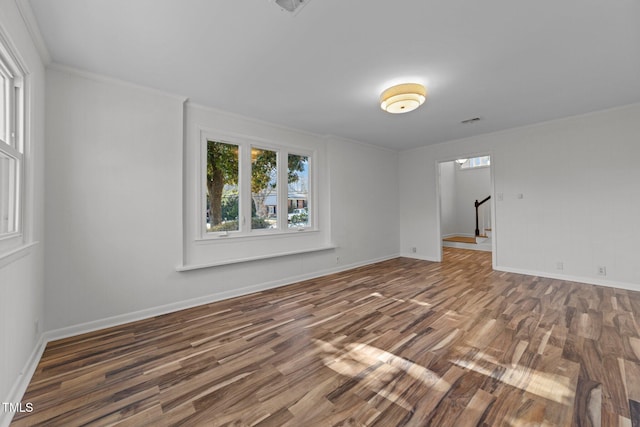 empty room with crown molding and dark wood-type flooring