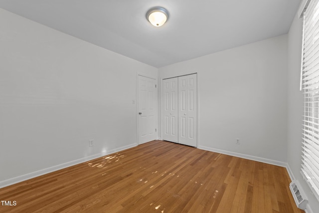 unfurnished bedroom featuring hardwood / wood-style flooring and a closet