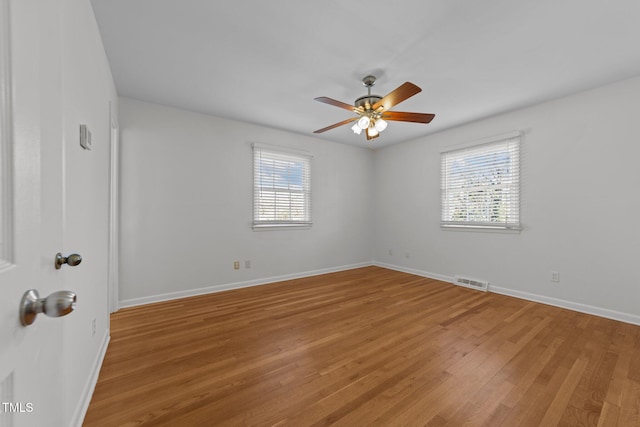 spare room with ceiling fan, plenty of natural light, and hardwood / wood-style floors