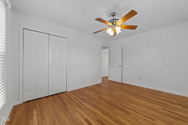 unfurnished bedroom featuring hardwood / wood-style floors, ceiling fan, and a closet