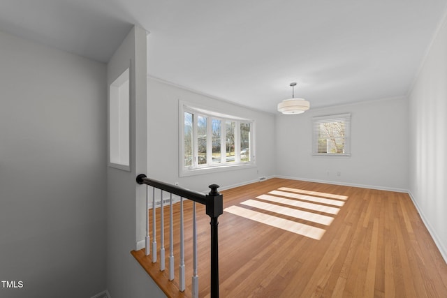 unfurnished room with light wood-type flooring and crown molding