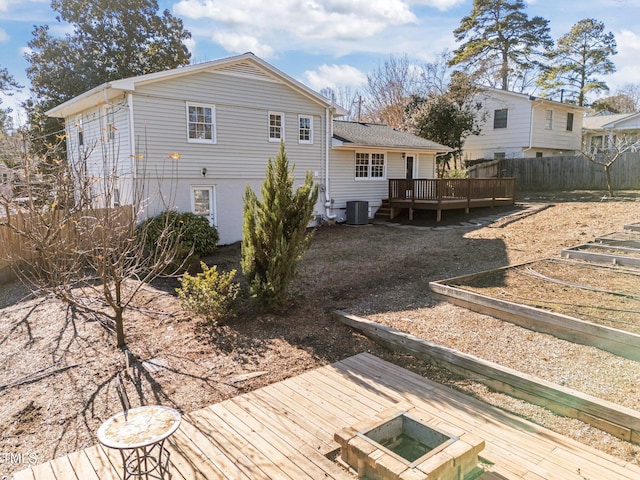 rear view of property featuring cooling unit and a wooden deck