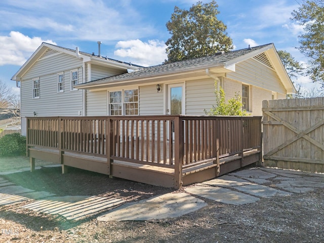 rear view of property featuring a wooden deck