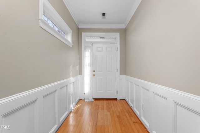 doorway featuring light wood-type flooring and ornamental molding