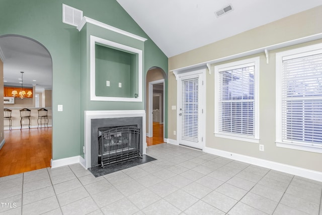 unfurnished living room with light tile patterned flooring, a chandelier, and lofted ceiling