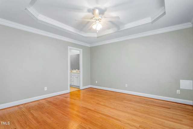 unfurnished room with a raised ceiling and crown molding