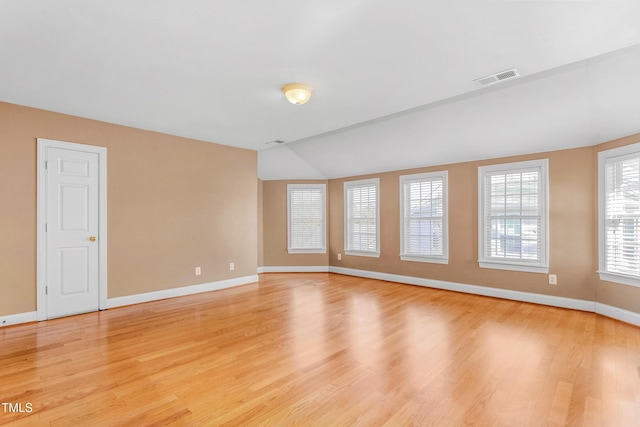 unfurnished room with light hardwood / wood-style floors and lofted ceiling