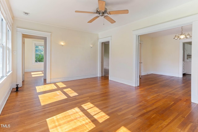 1308 Wake Forest Rd, Raleigh, NC 27604 - spare room featuring a chandelier, wood finished floors, ornamental molding, ceiling fan, and baseboards