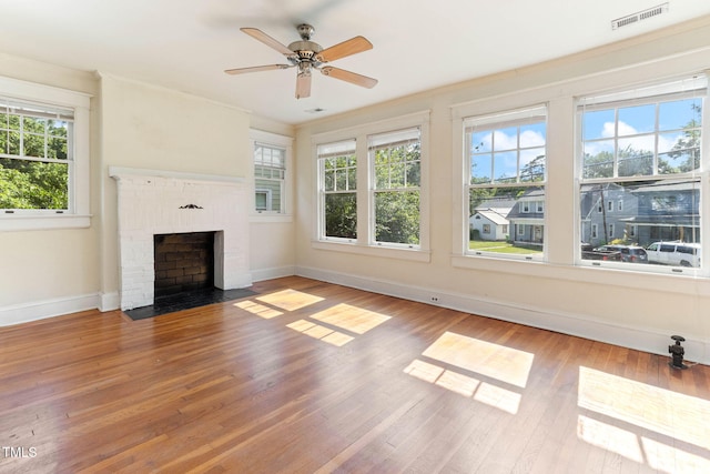 1308 Wake Forest Rd, Raleigh, NC 27604 - unfurnished living room with baseboards, wood finished floors, crown molding, ceiling fan, and a brick fireplace