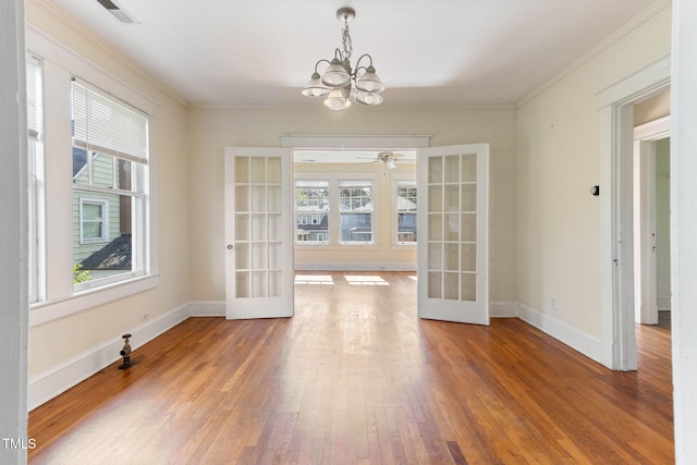 1308 Wake Forest Rd, Raleigh, NC 27604 - unfurnished dining area featuring french doors, healthy amount of natural light, a chandelier, hardwood / wood-style floors, and crown molding