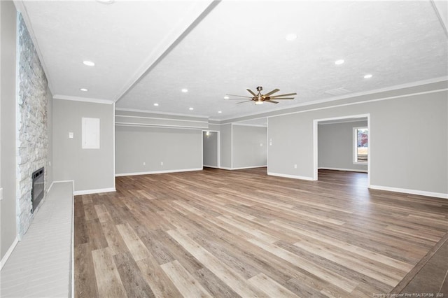 unfurnished living room featuring a fireplace, light wood-type flooring, ceiling fan, and crown molding