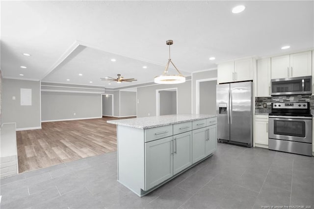 kitchen with crown molding, ceiling fan, pendant lighting, and appliances with stainless steel finishes