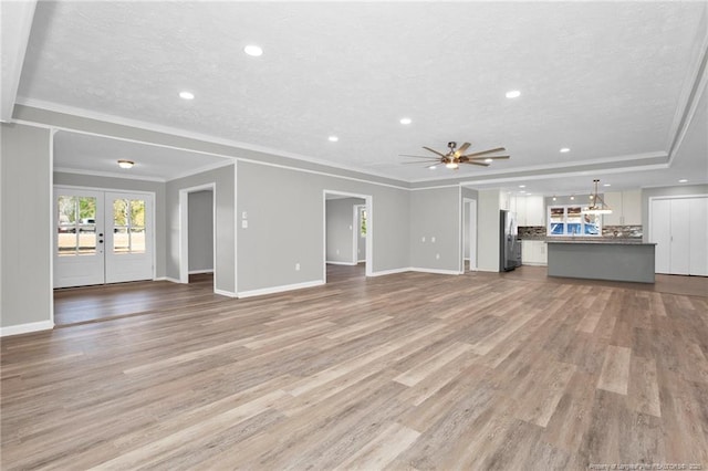 unfurnished living room with french doors, light hardwood / wood-style flooring, ceiling fan, and crown molding