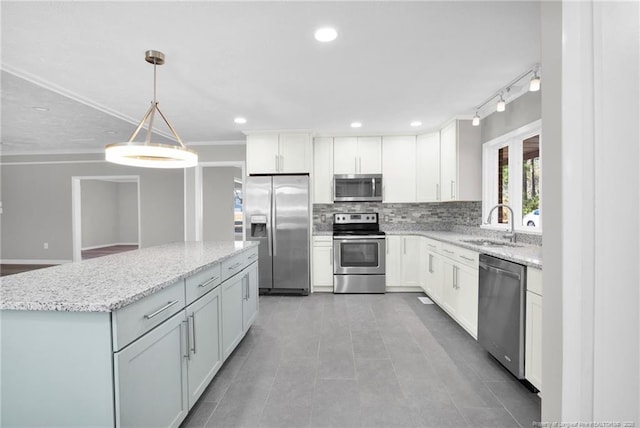 kitchen with white cabinetry, sink, stainless steel appliances, decorative light fixtures, and decorative backsplash