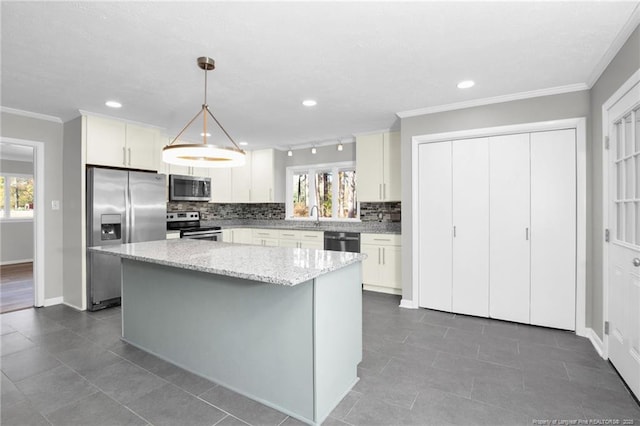 kitchen with a center island, white cabinets, appliances with stainless steel finishes, tasteful backsplash, and decorative light fixtures