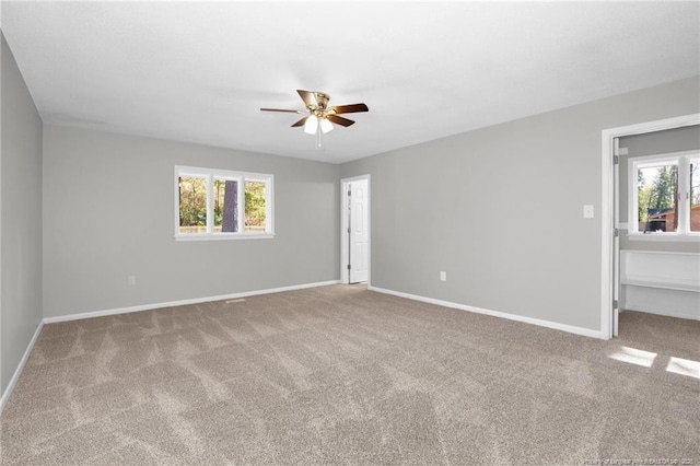 spare room featuring light colored carpet and ceiling fan