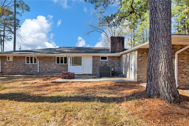 back of property featuring a lawn, cooling unit, and a patio area