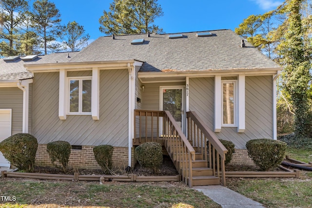 view of front facade with a shingled roof and crawl space