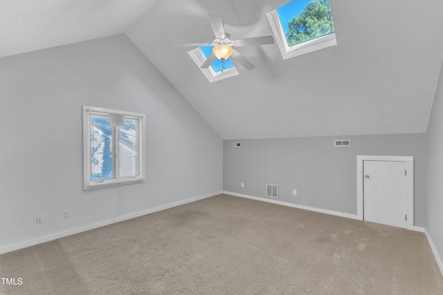 additional living space featuring a ceiling fan, light colored carpet, and visible vents