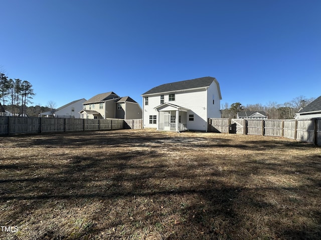 rear view of house featuring a yard