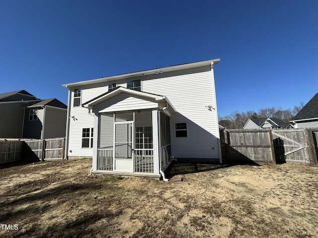 rear view of house featuring a sunroom