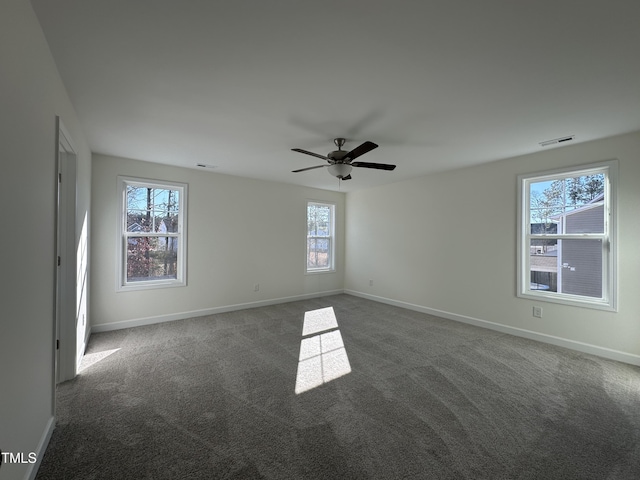 unfurnished room with ceiling fan and dark colored carpet