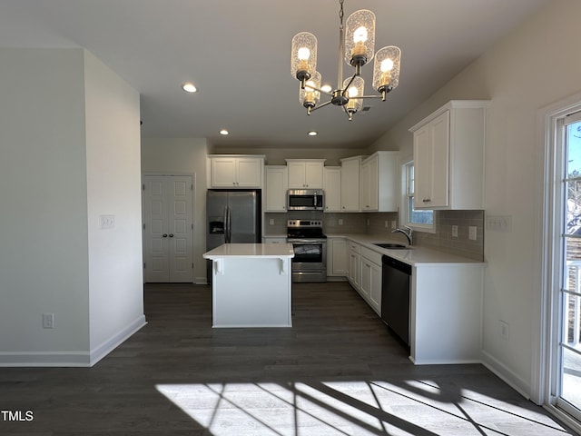 kitchen featuring a center island, sink, hanging light fixtures, a notable chandelier, and stainless steel appliances