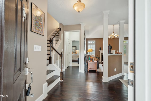 entryway with a textured ceiling, dark hardwood / wood-style floors, and an inviting chandelier