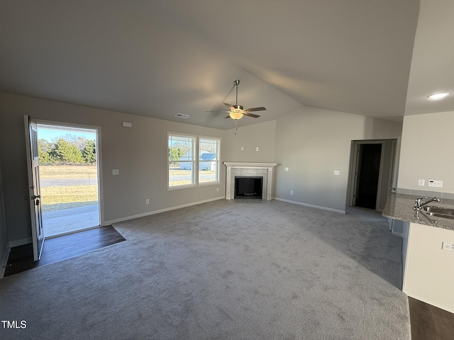 unfurnished living room with carpet, ceiling fan, lofted ceiling, and sink