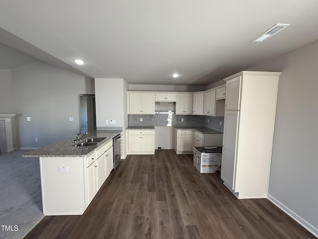 kitchen featuring white cabinets, dark stone countertops, sink, and tasteful backsplash