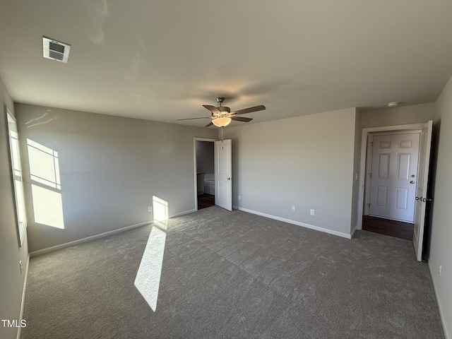 unfurnished bedroom with ceiling fan and dark carpet