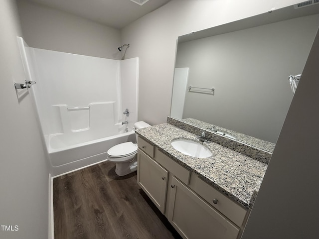 full bathroom with hardwood / wood-style flooring, vanity, toilet, and washtub / shower combination