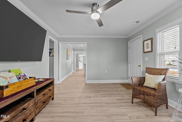 living area featuring crown molding, light hardwood / wood-style flooring, and ceiling fan