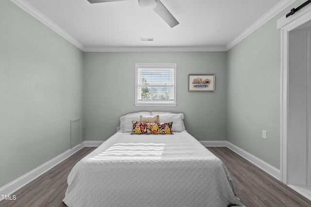 bedroom with dark hardwood / wood-style flooring, ornamental molding, a barn door, and ceiling fan