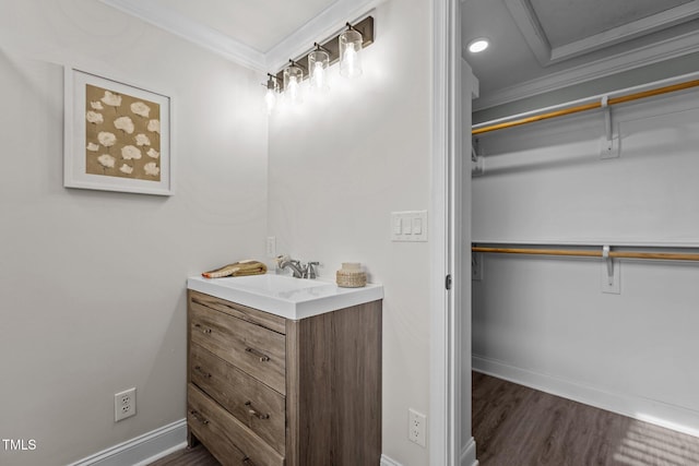 bathroom featuring vanity, wood-type flooring, and ornamental molding