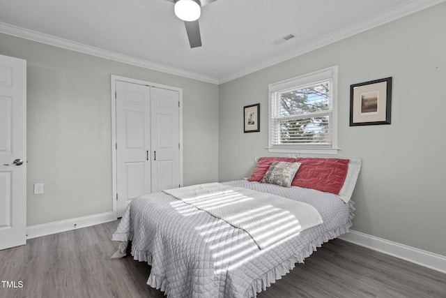 bedroom with wood-type flooring, crown molding, ceiling fan, and a closet