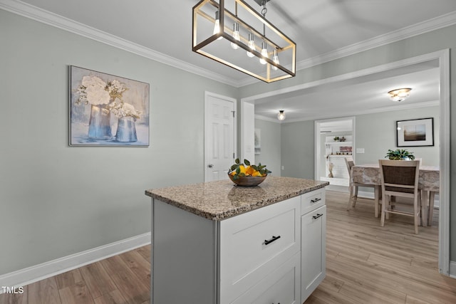 kitchen featuring white cabinetry, hanging light fixtures, a kitchen island, built in shelves, and light wood-type flooring