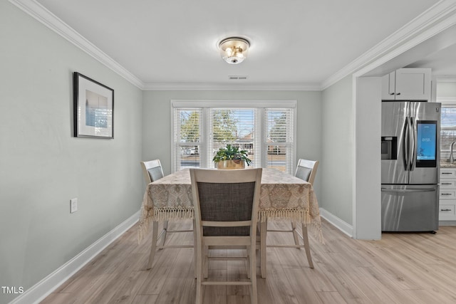 dining space featuring light hardwood / wood-style flooring and ornamental molding