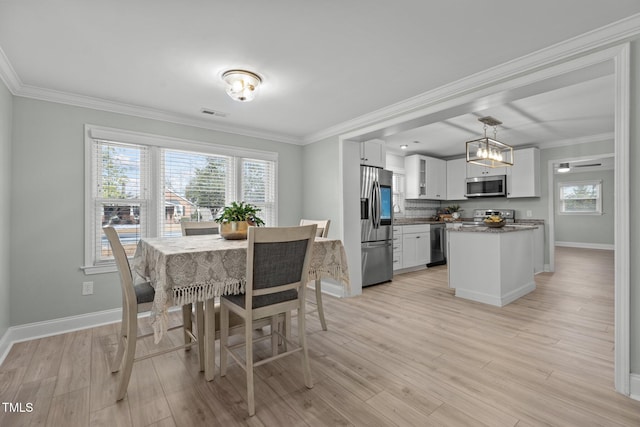 dining room featuring crown molding and light hardwood / wood-style floors