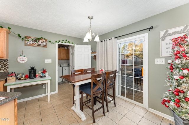 dining area with a notable chandelier, independent washer and dryer, a textured ceiling, and light tile patterned floors