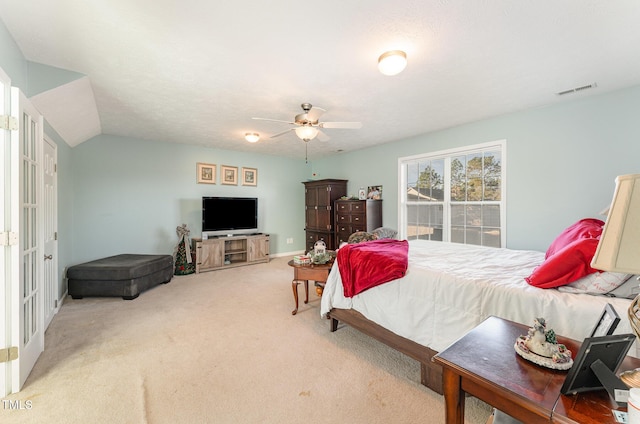 bedroom with a textured ceiling, carpet floors, vaulted ceiling, and ceiling fan