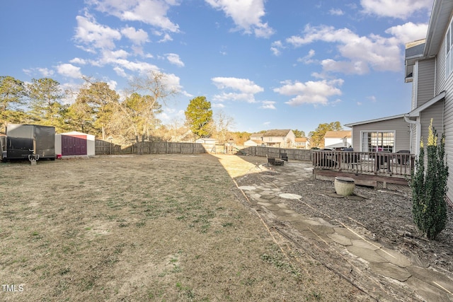 view of yard featuring a storage unit and a deck